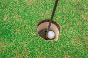 Assicurazione Golf Hole in One - Primo piano: palla da golf nella buca