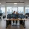 Cyber Hygiene NIS 2: ufficio con monitor e team IT su skyline Milano per sicurezza informatica aziendale