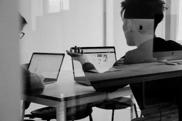 due professionisti al pc su scrivania in ufficio moderno
