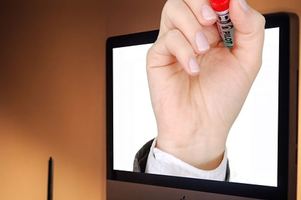AlphabetCity racconta Pico Adviser: mano con pennarello che emerge dallo schermo di un iMac